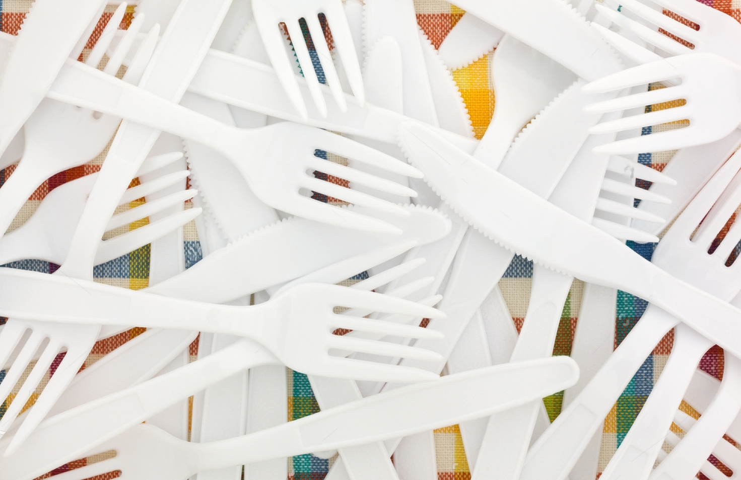 stock-photo-close-view-of-white-plastic-forks-and-knives-on-a-colorful-tablecloth-735630520-transformed